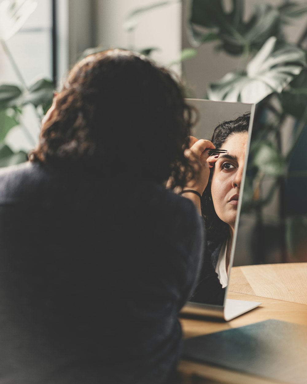 a woman is looking in a mirror at her reflection