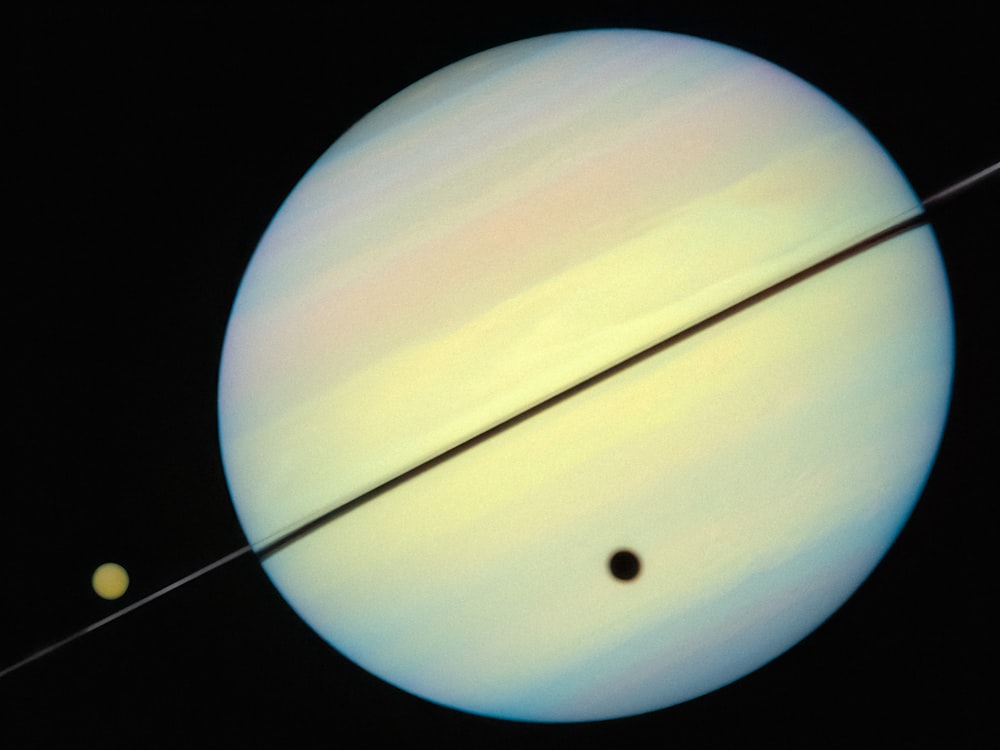 a picture of the planet saturn and its two satellites