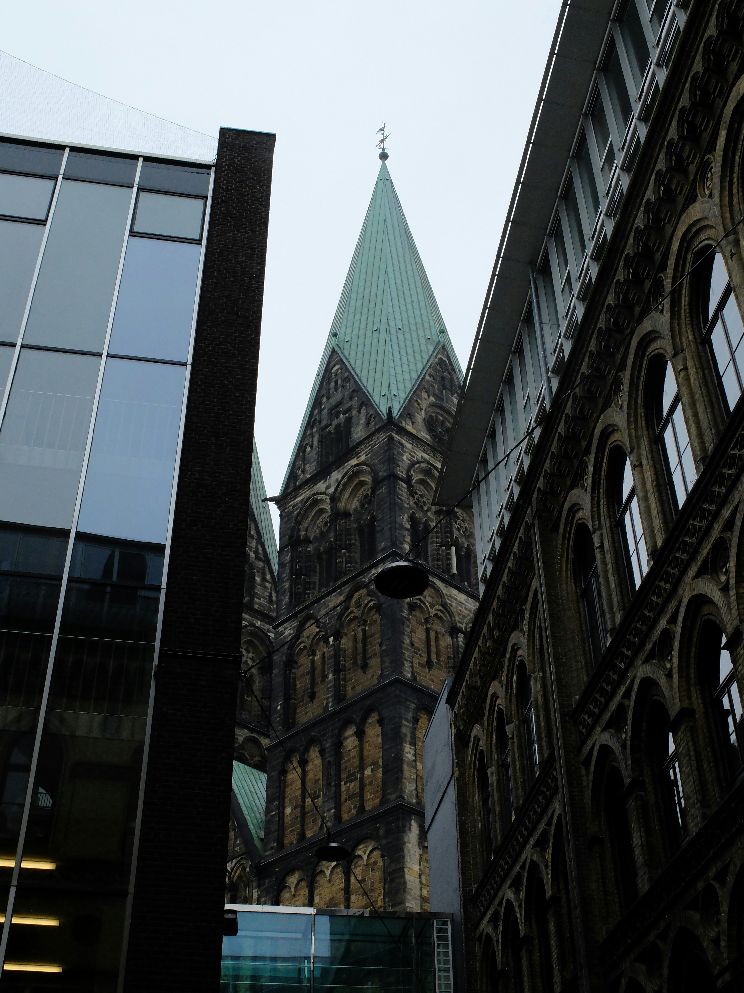 a tall building with a steeple next to other buildings