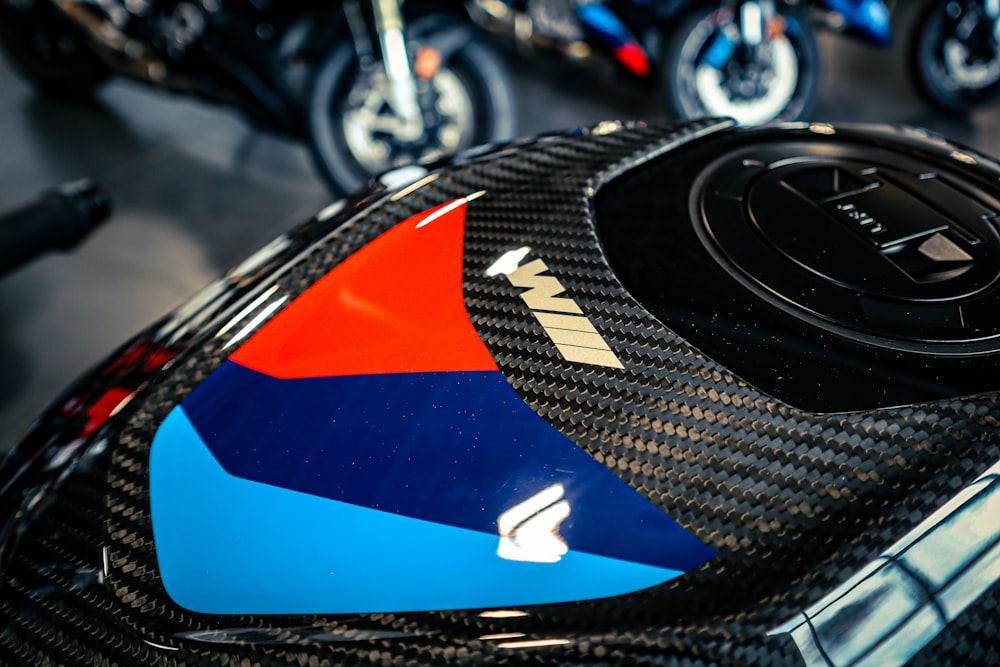 a close up of a motorcycle with a red, blue, and orange design