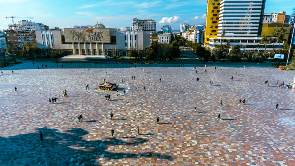 a group of people standing around a fountain in the middle of a city