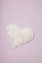 a pile of white pills in the shape of a heart
