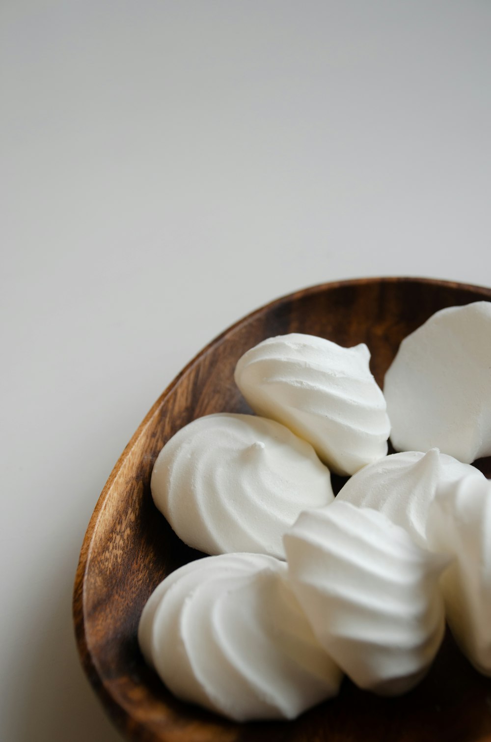 a wooden bowl filled with whipped cream on top of a table