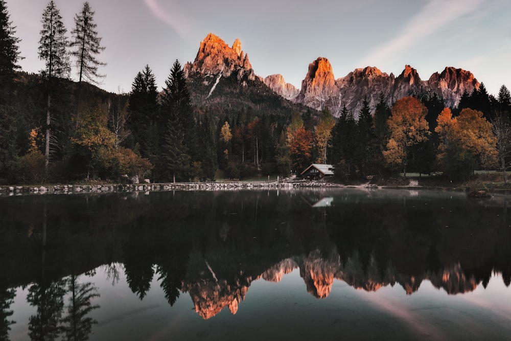 a lake surrounded by trees with mountains in the background