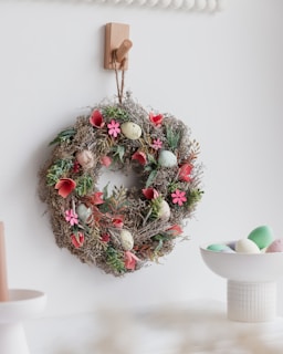 a wreath hanging on a wall next to a bowl of eggs