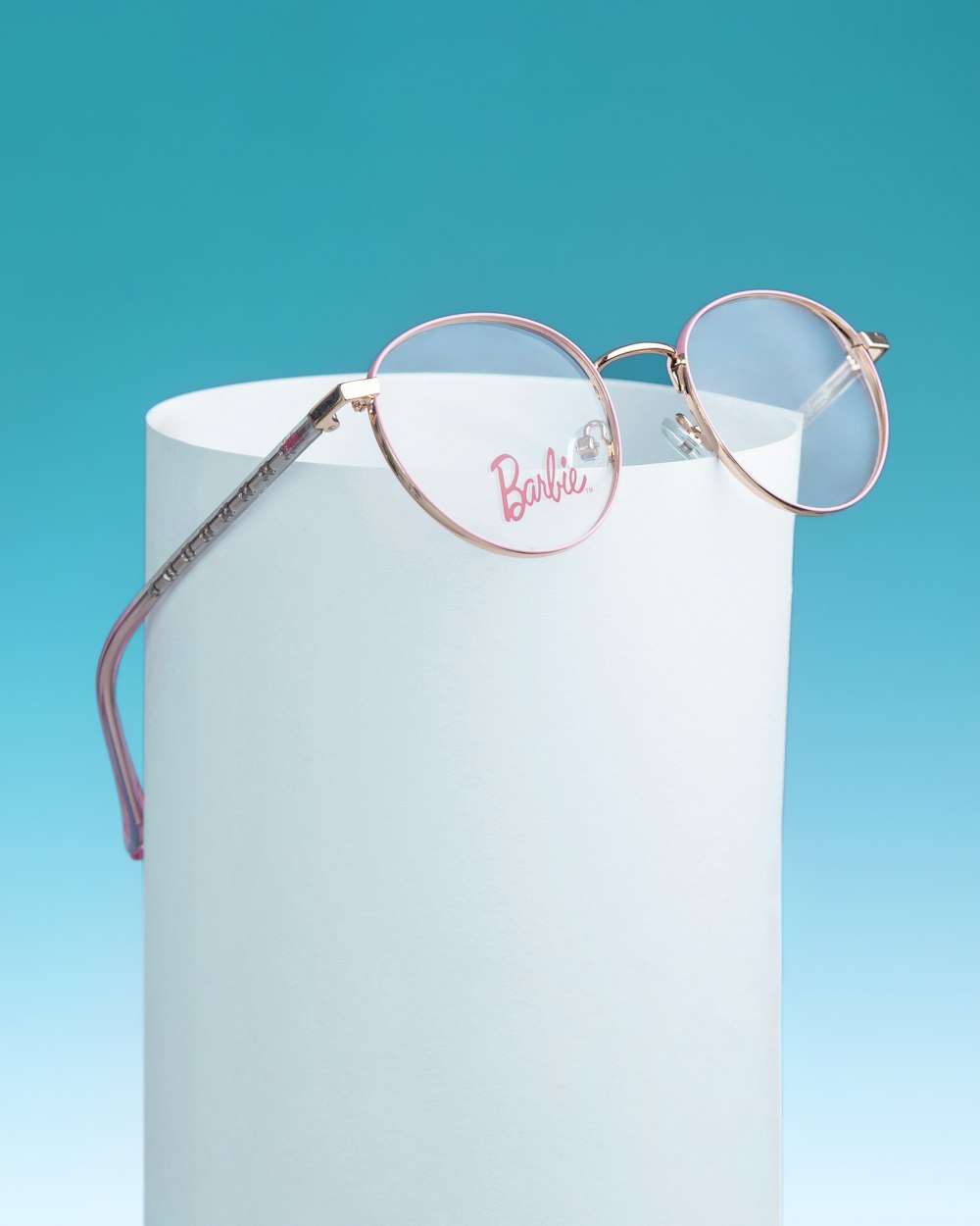 a pair of glasses sitting on top of a white box