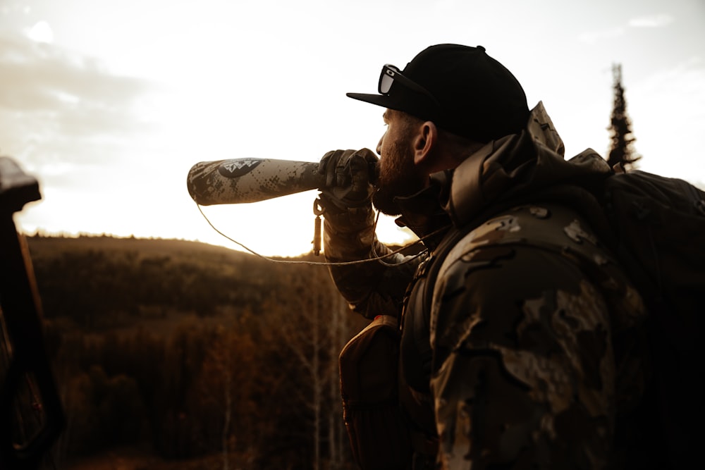 a man with a beard and a hat drinking from a water bottle