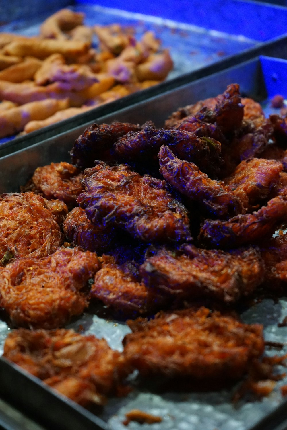 a tray of fried food next to other trays of fried food