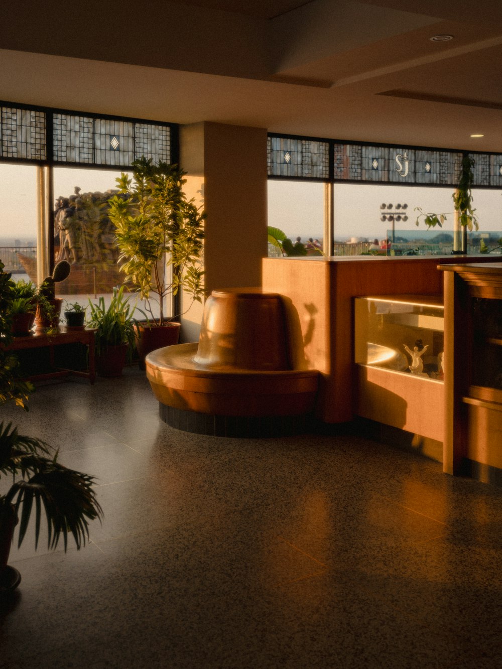 a room with a large window and a plant in the corner