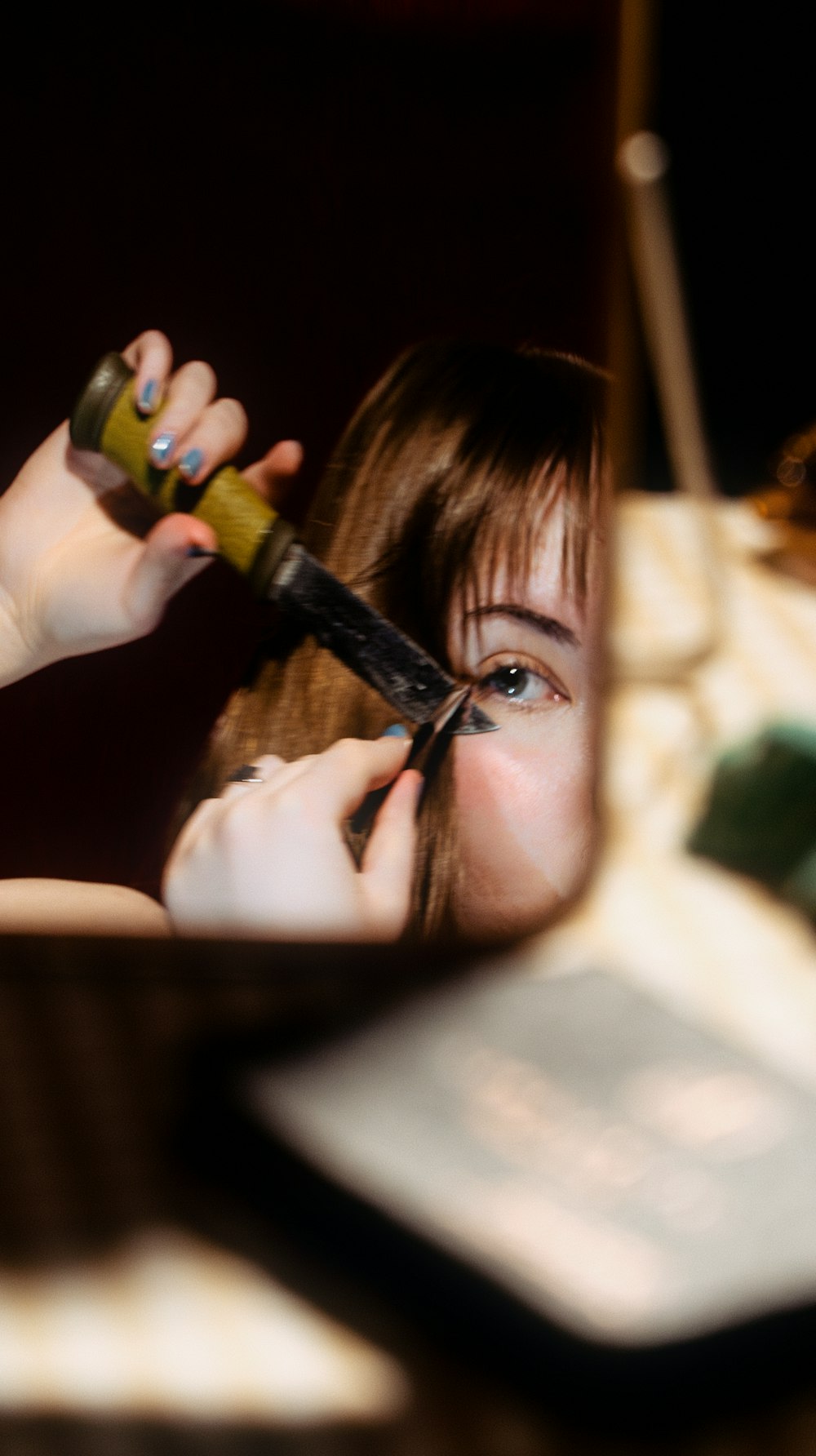 a woman cutting her hair with a pair of scissors