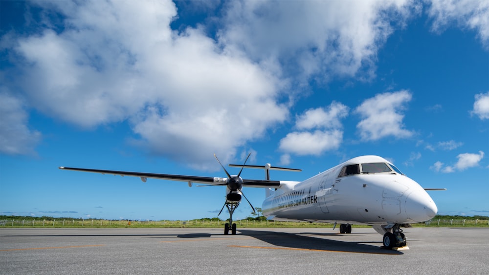 a white airplane sitting on top of an airport tarmac