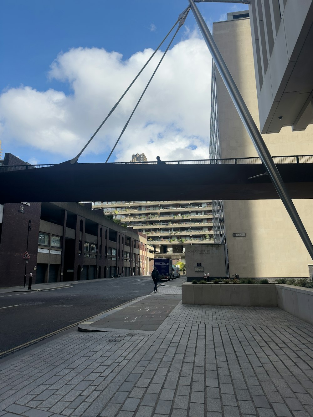 a person walking down a street under a bridge