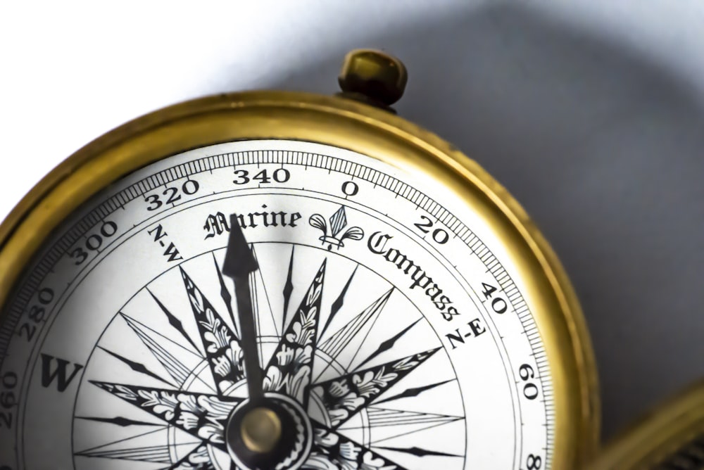 a close up of a compass on a white background