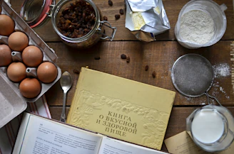 Traditional recipe book with fresh baking ingredients on a wooden table