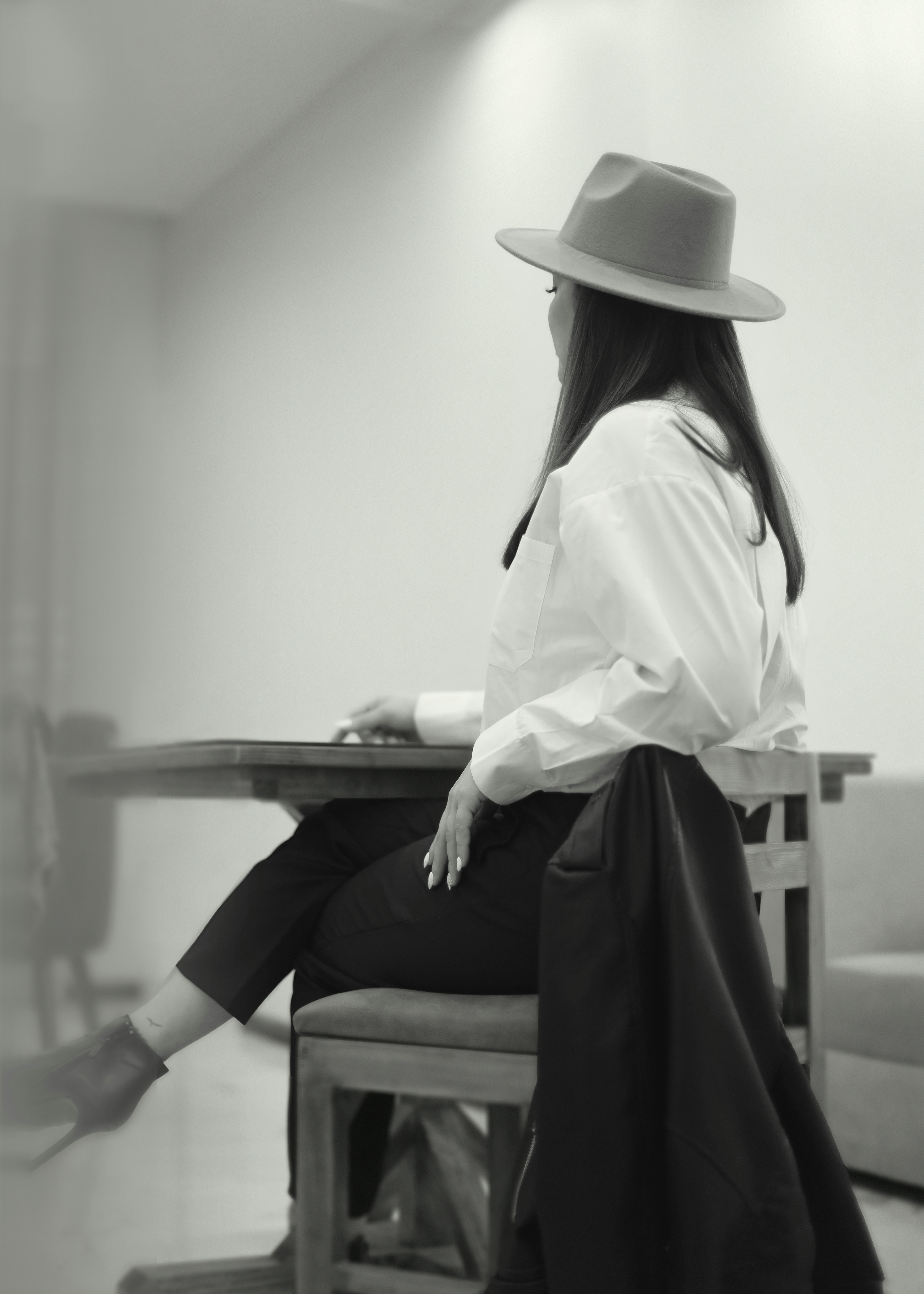 a woman sitting at a table with a hat on