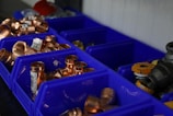 a bunch of blue bins filled with lots of copper