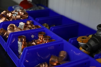a bunch of blue bins filled with lots of copper
