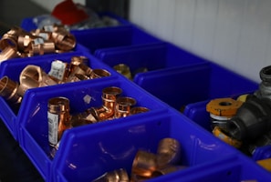 a bunch of blue bins filled with lots of copper