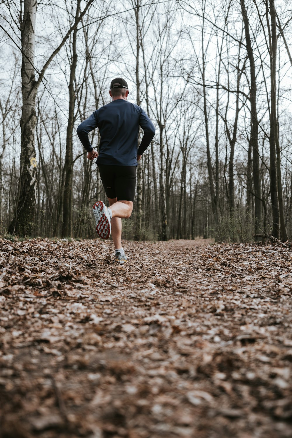 a man running in the woods with his back to the camera