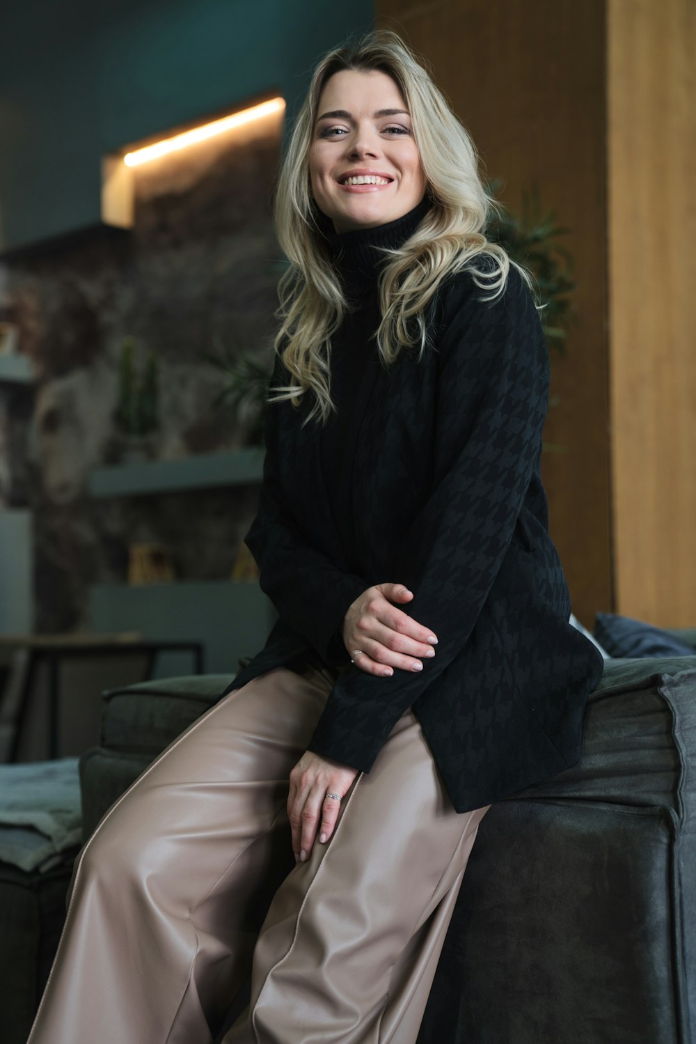 a woman sitting on top of a black couch