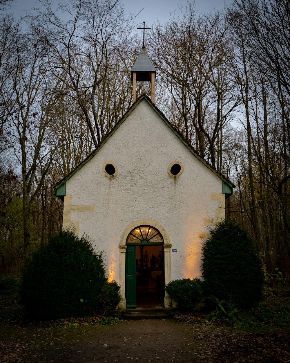 a white church with a green door and a steeple