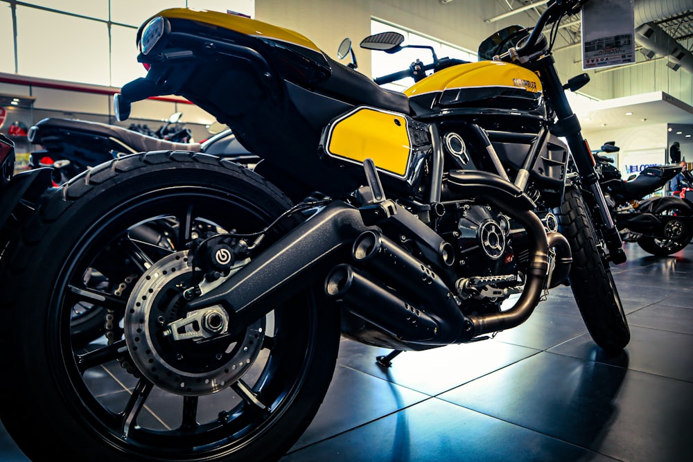 a yellow and black motorcycle parked inside of a building