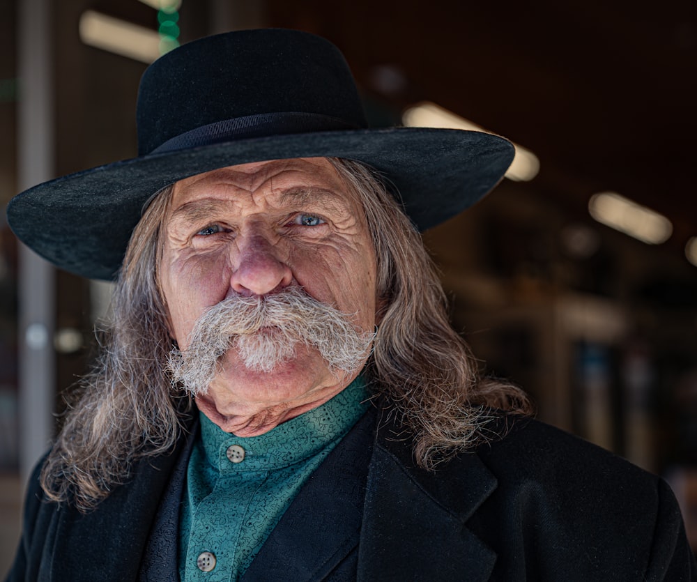 a man with a long beard wearing a black hat