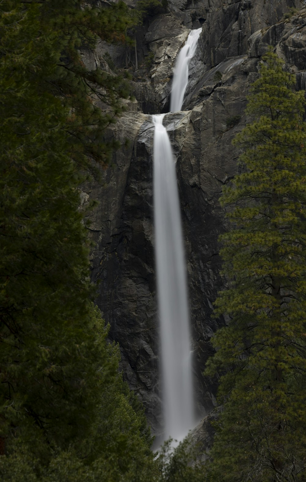 Une grande cascade est vue à travers les arbres