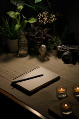 a table with a notebook, candles and a camera