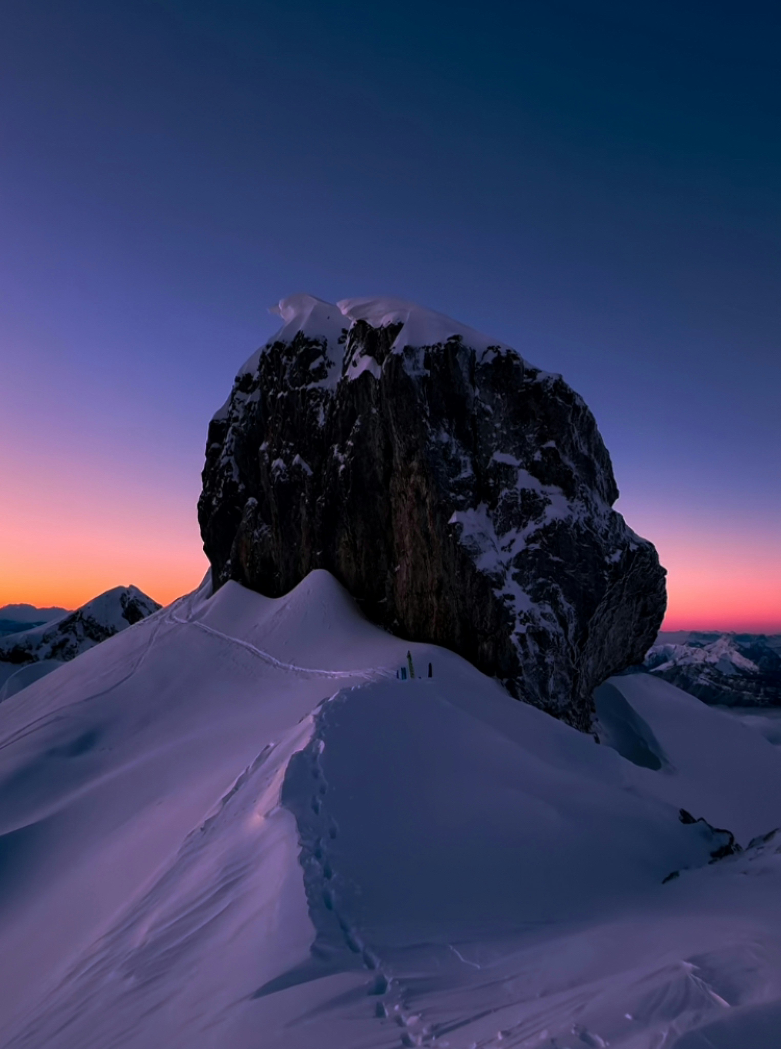 a snow covered mountain with a large rock sticking out of it's side