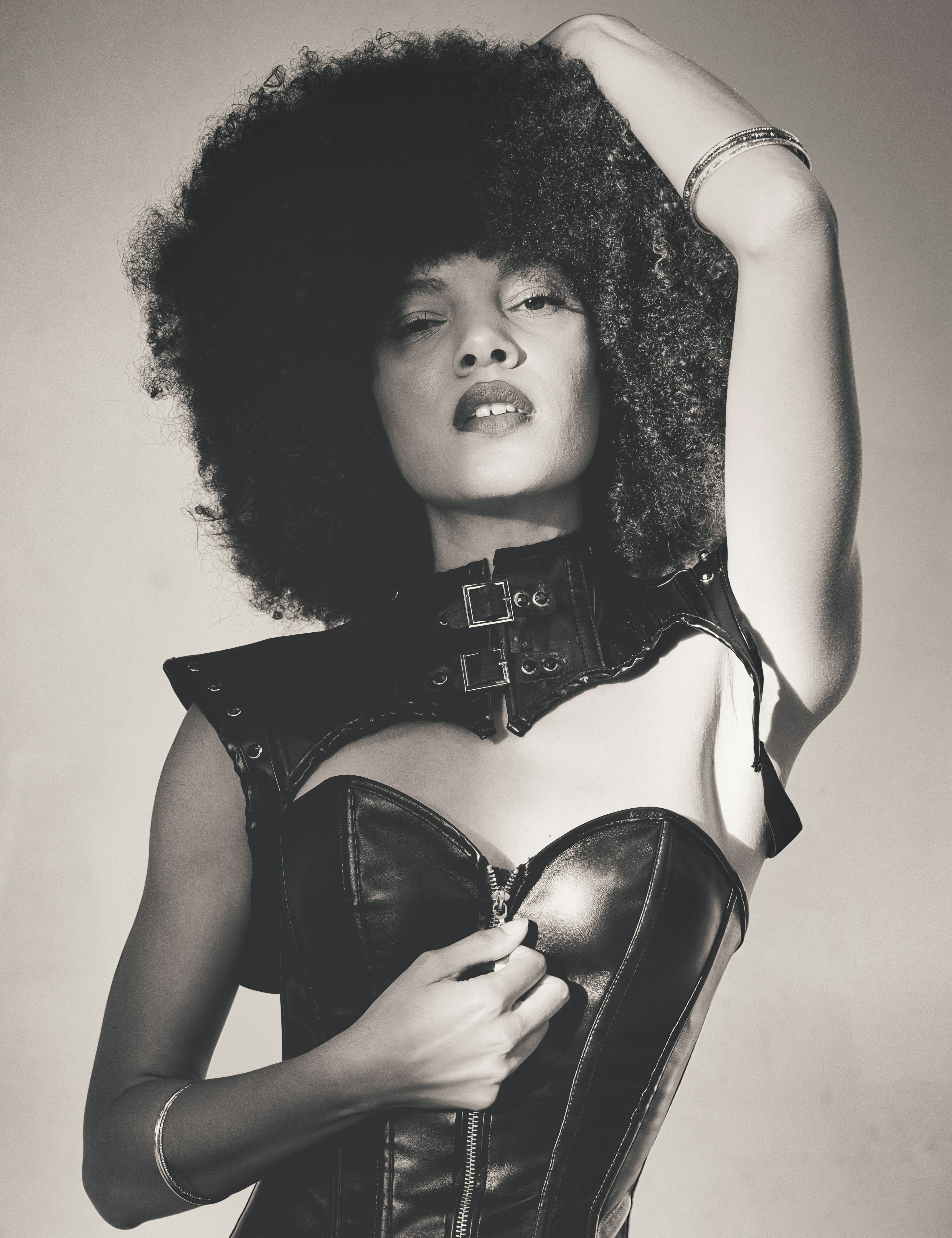 a woman in a corset with her hands on her head