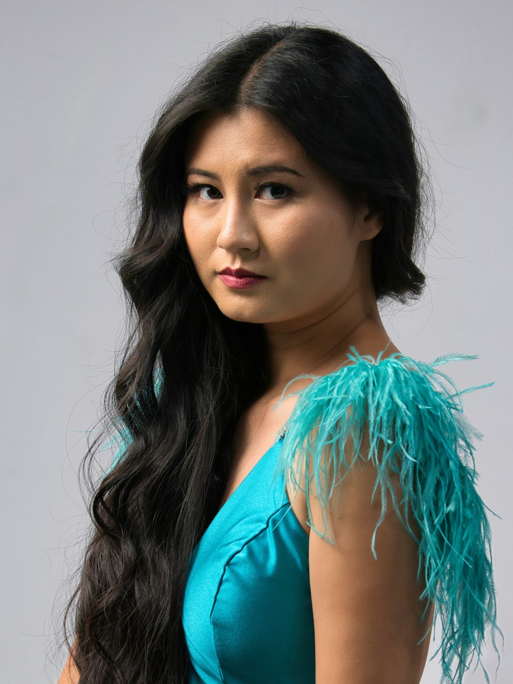 a woman with long black hair wearing a blue dress