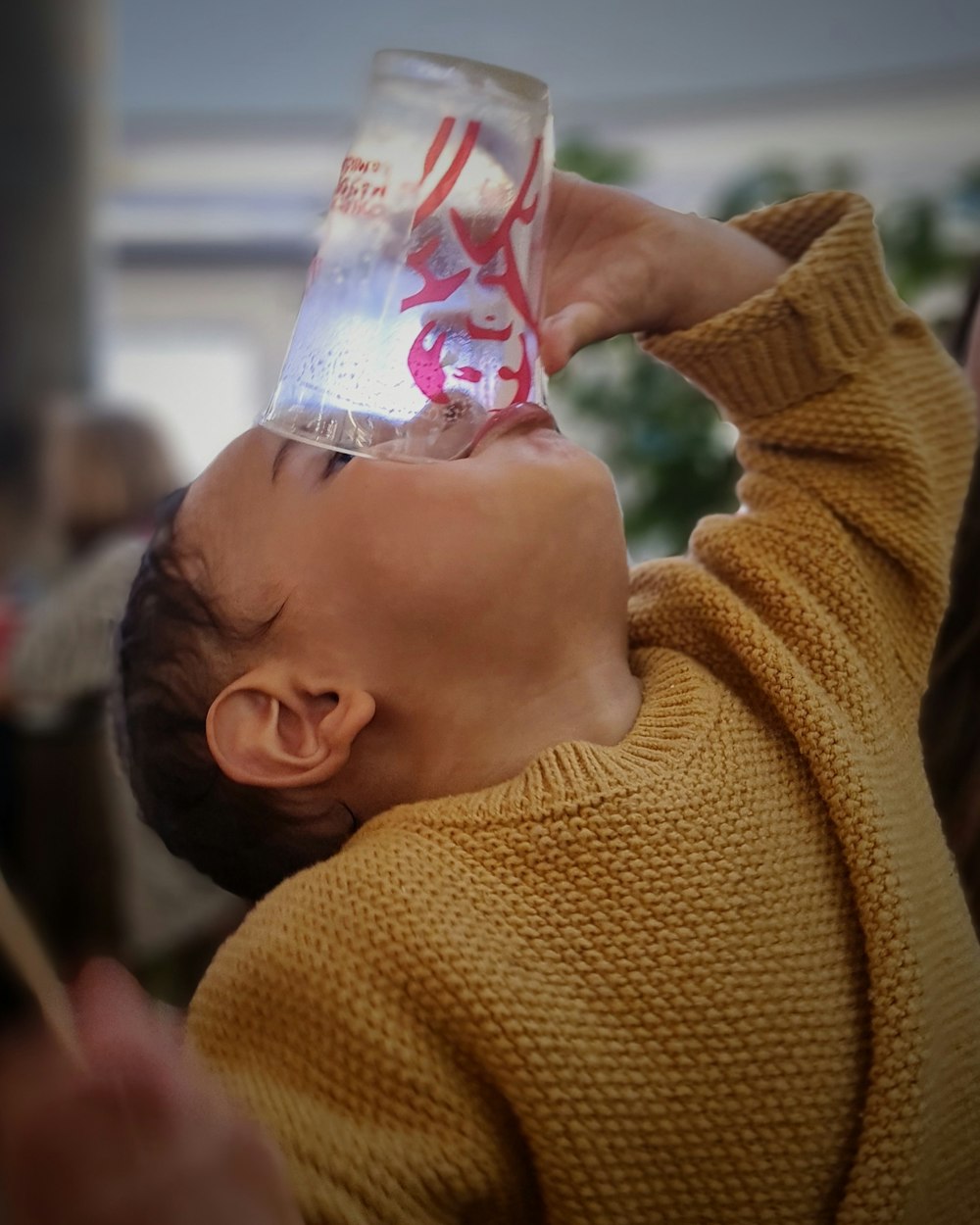 a woman holding a plastic cup up to her head