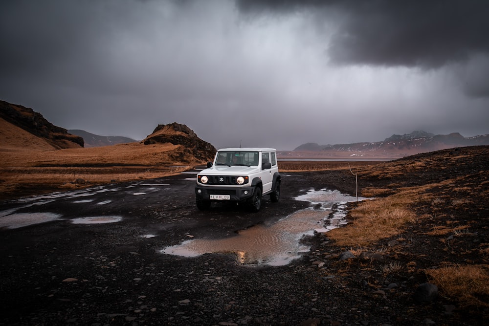 a white jeep is parked on the side of the road