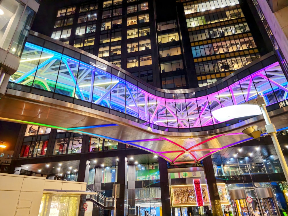 a very tall building with a lit up walkway in front of it