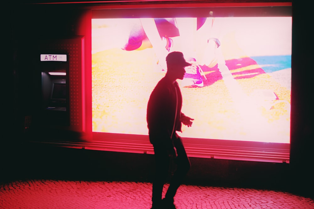 a man standing in front of a big screen