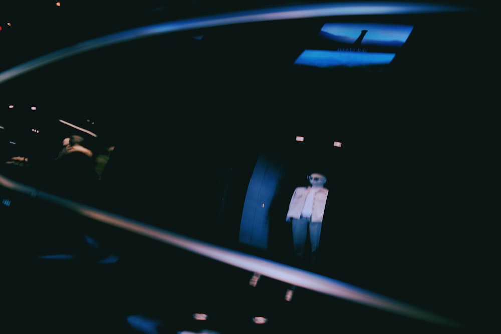 a person in a white suit standing in a dark room