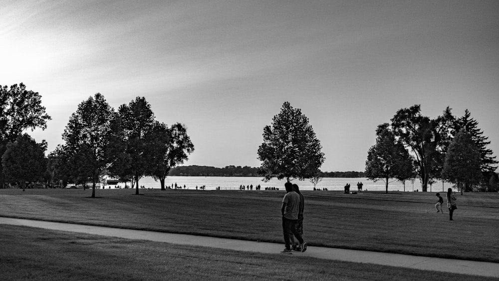 a black and white photo of a man standing in a park