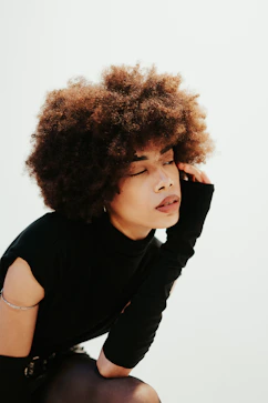 a woman with an afro sitting on the ground