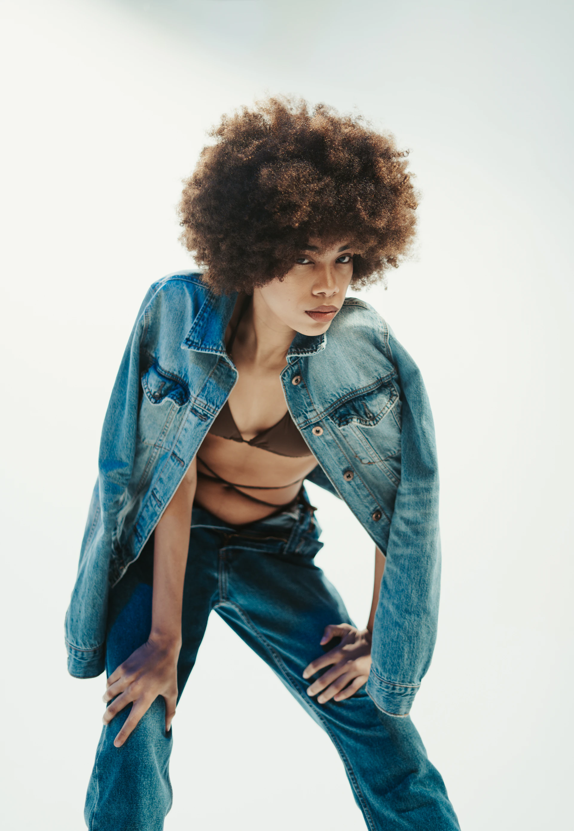 a woman wearing a jean jacket and jeans