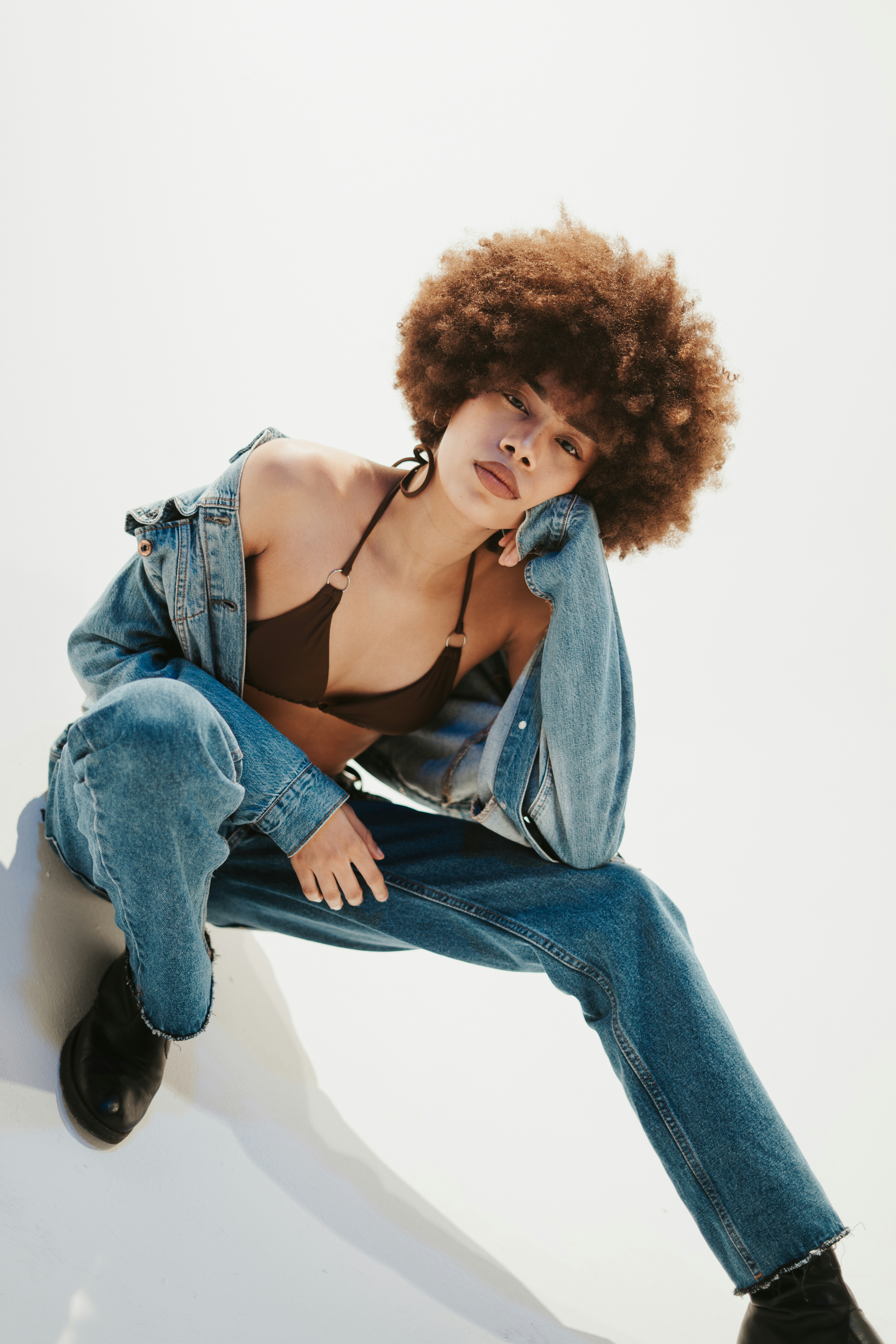 a woman with an afro sitting on a skateboard