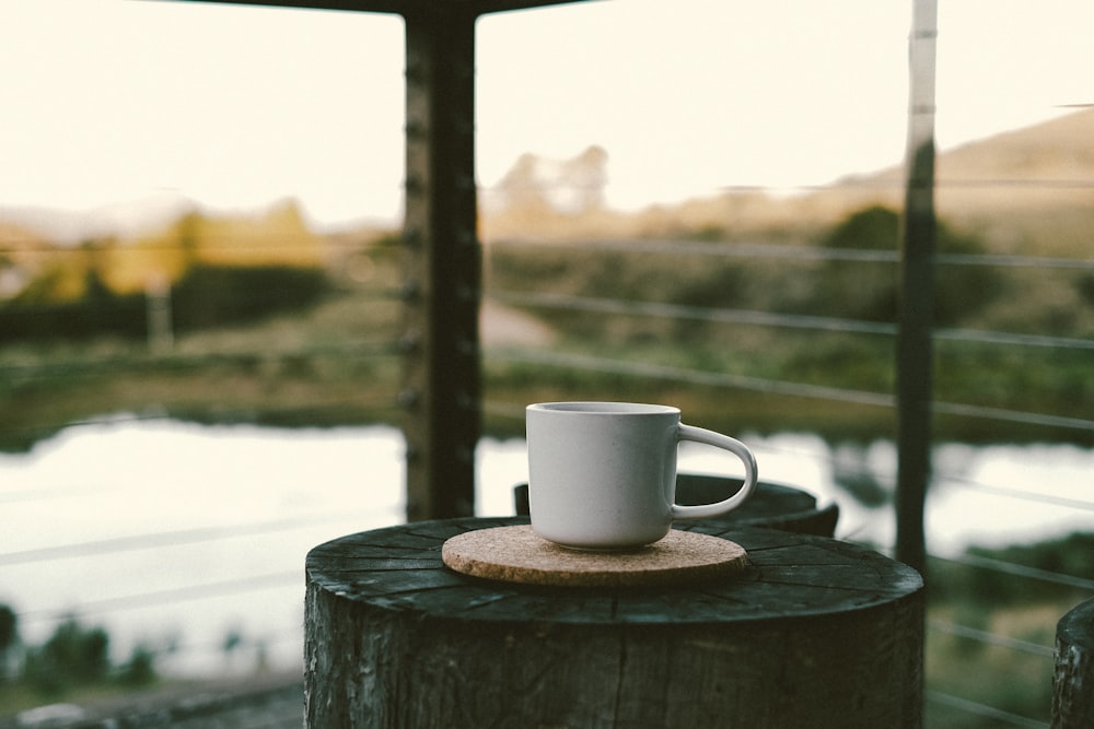 a cup of coffee sitting on top of a wooden table