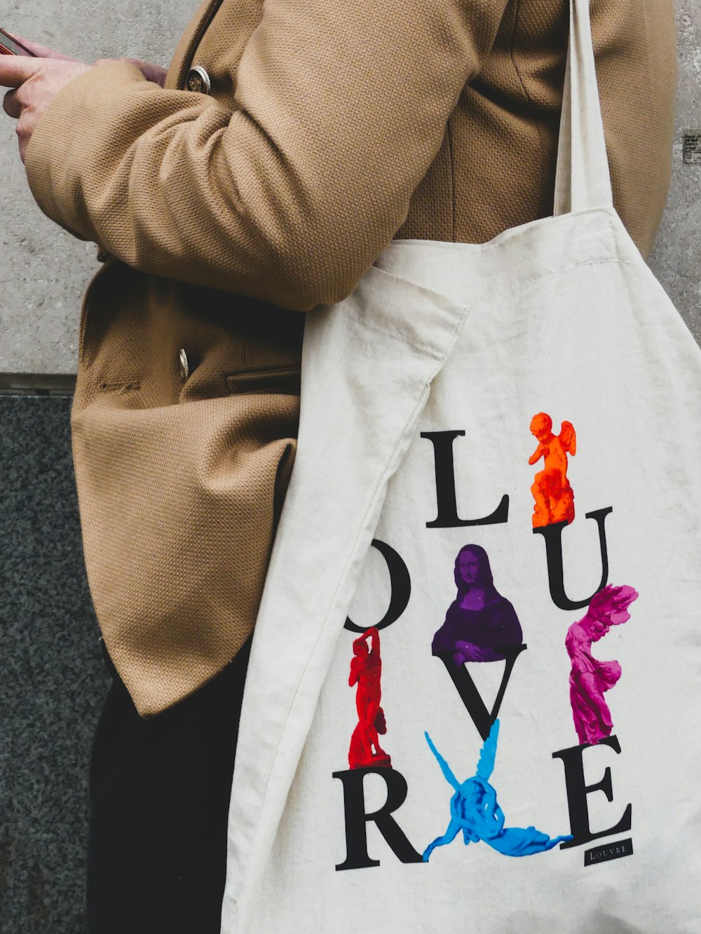 a woman carrying a white tote bag with the word love on it