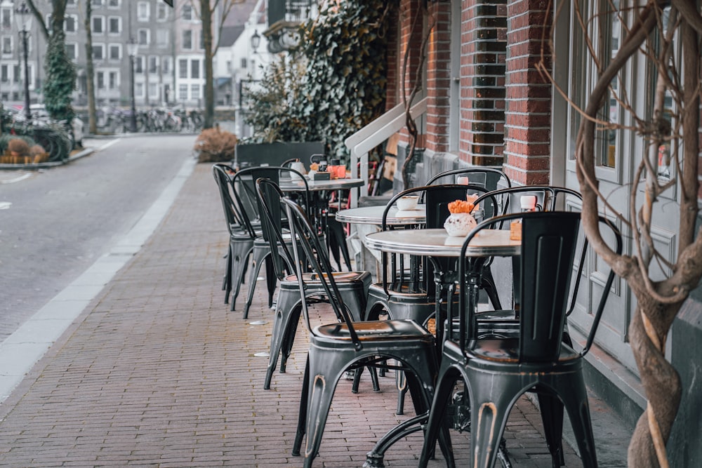 a row of tables and chairs on a sidewalk