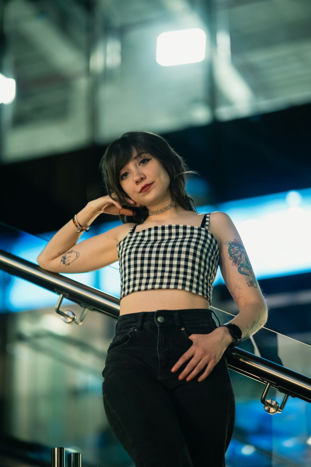 a woman in a crop top leaning on a rail