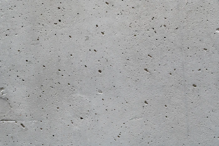 A porous cement surface pocked with small holes