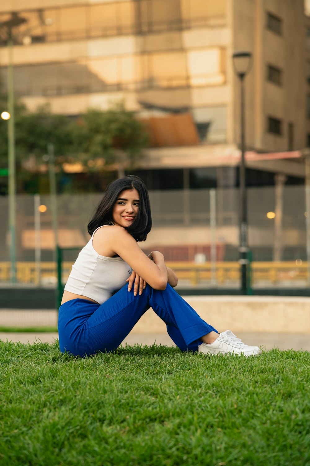 a woman sitting in the grass with her legs crossed