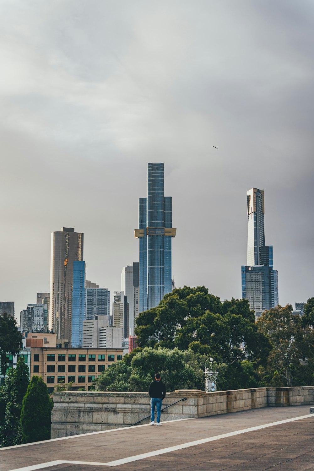 a man walking down a sidewalk in front of tall buildings