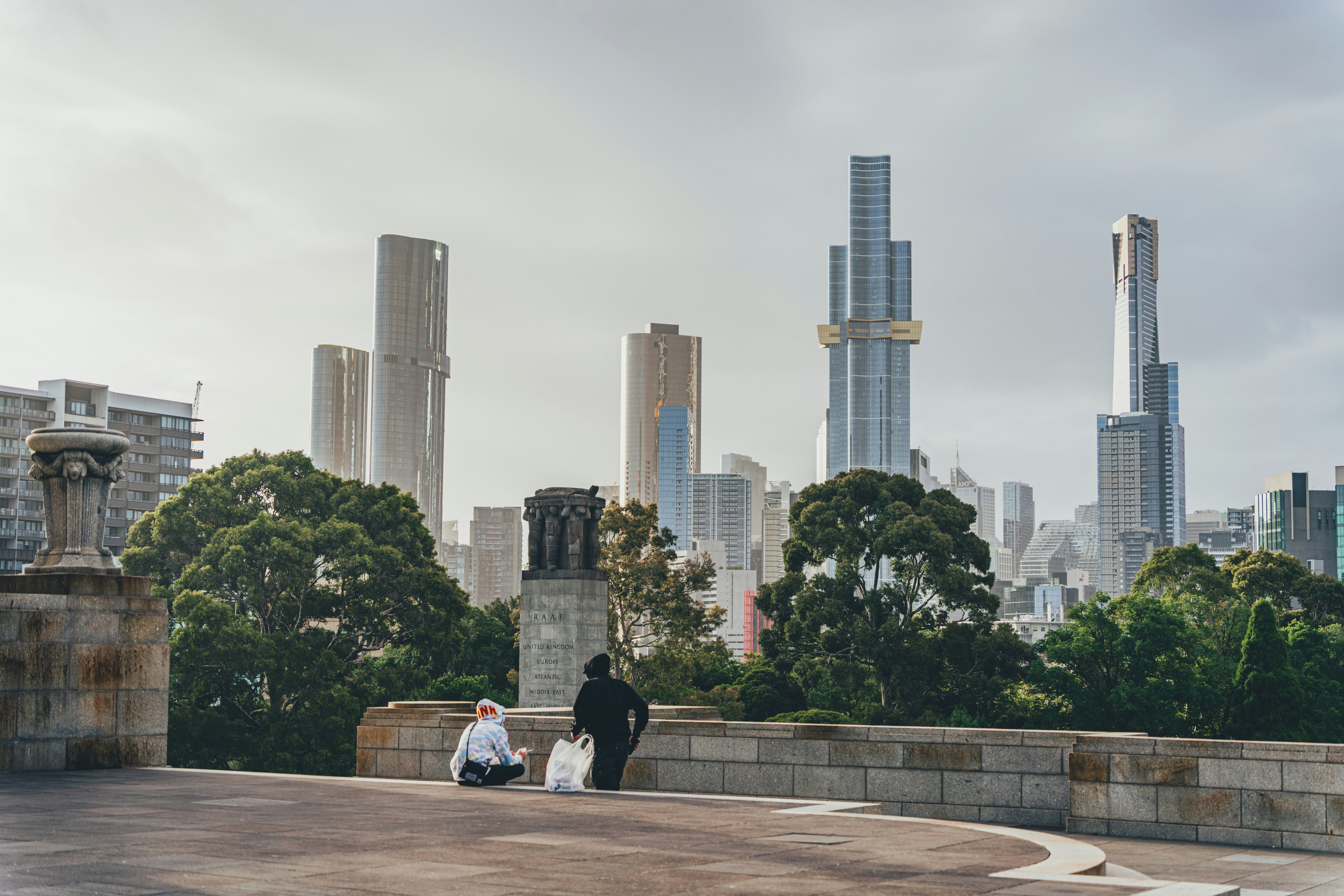 a couple of people sitting on top of a cement wall