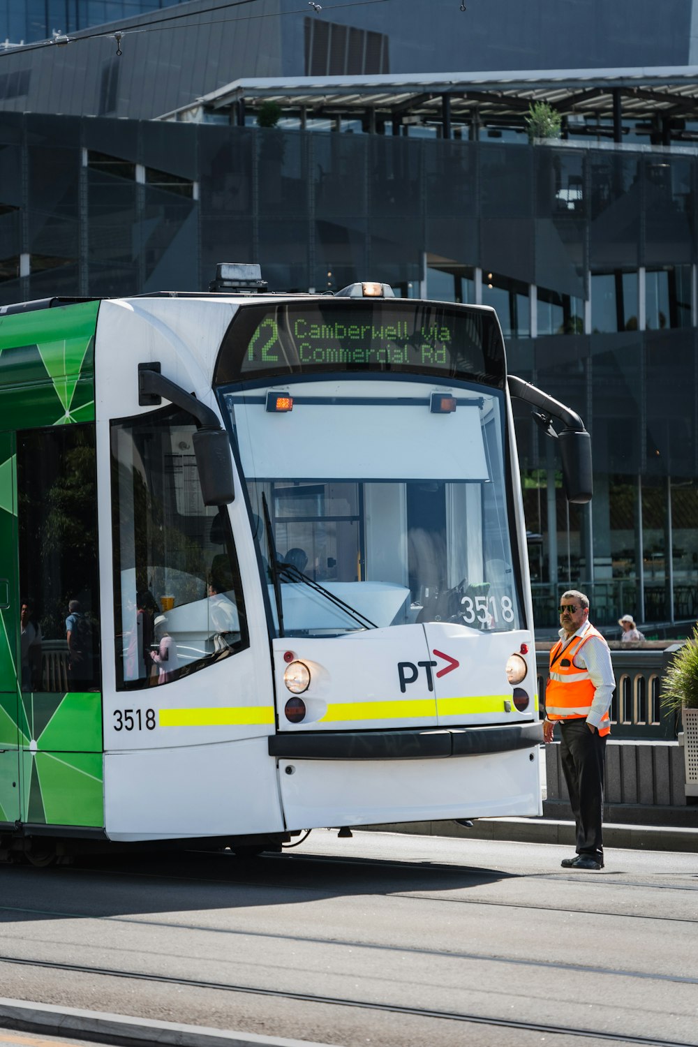 a man standing next to a green and white bus